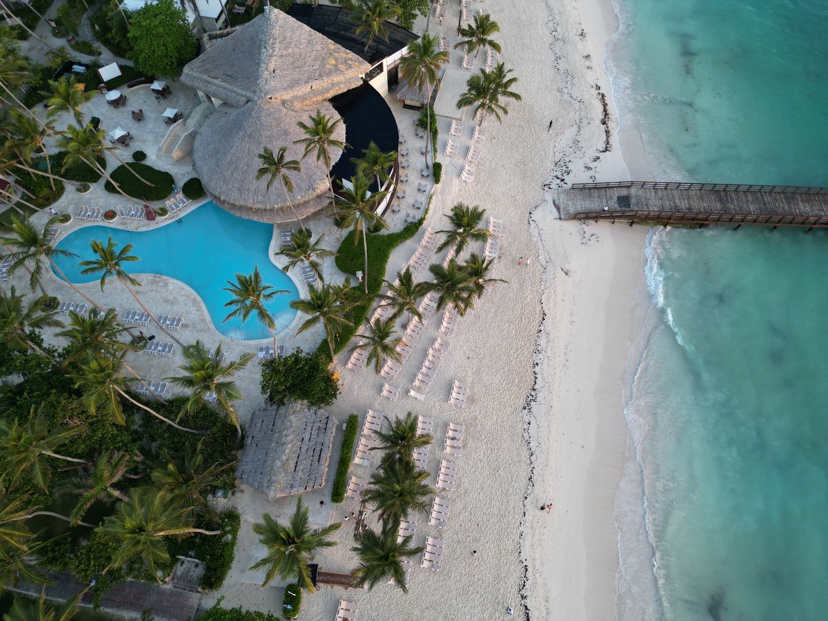 Aerial view of a beach resort pool and palm trees, a holiday that combines GDS flights with bedbank hotels in one package