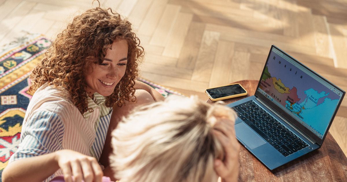 Two people planning a trip together on a laptop at home, the kind of customer search a travel booking engine has to turn into a confirmed booking