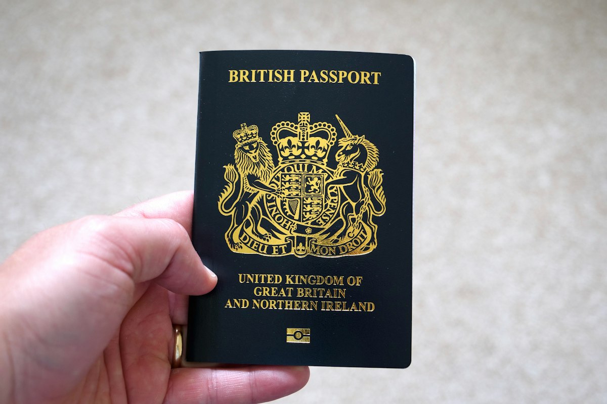 Hand holding a British passport, the travel document behind UK ATOL, ABTA and package travel protection rules