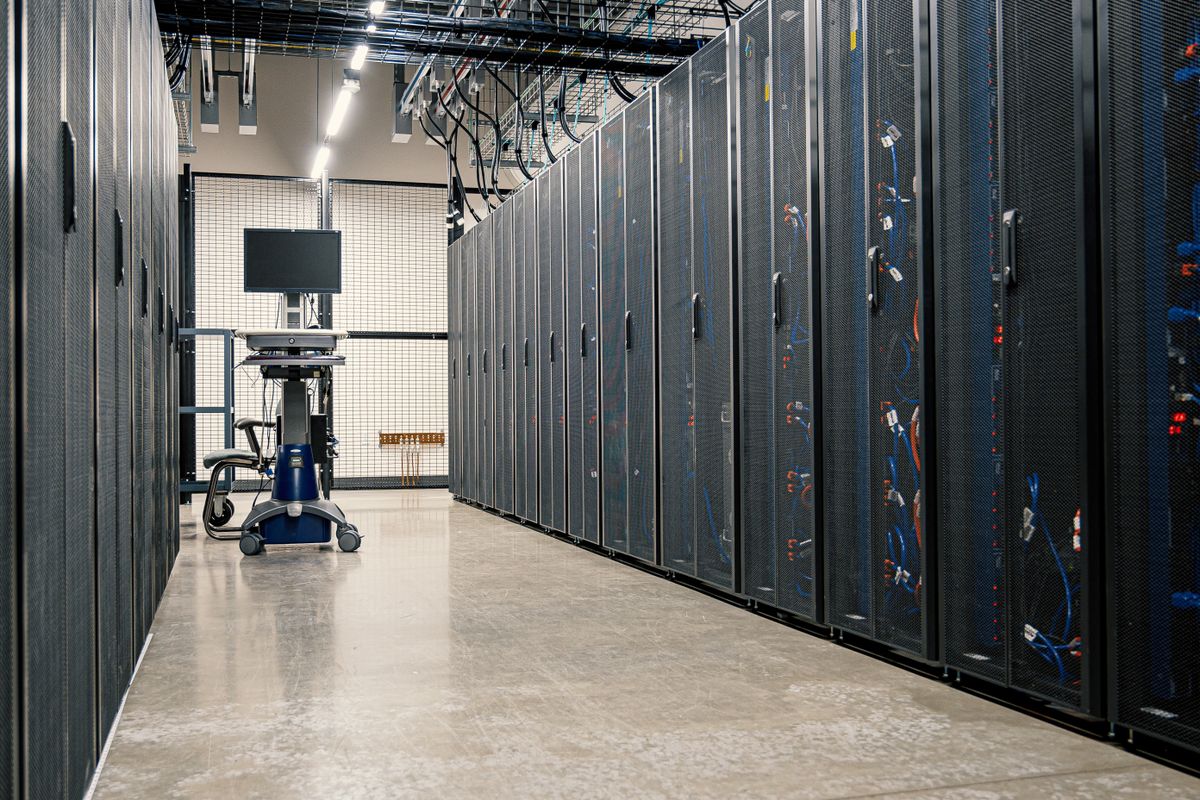 Rows of server racks in a data centre, representing the hosting, uptime and security work a self-built travel website must maintain